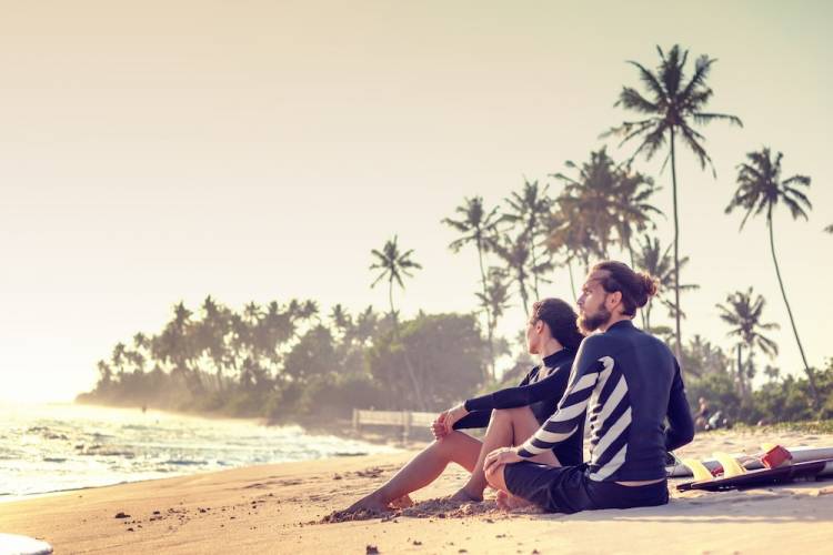 couple sitting on the beach looking at ocean on Maui