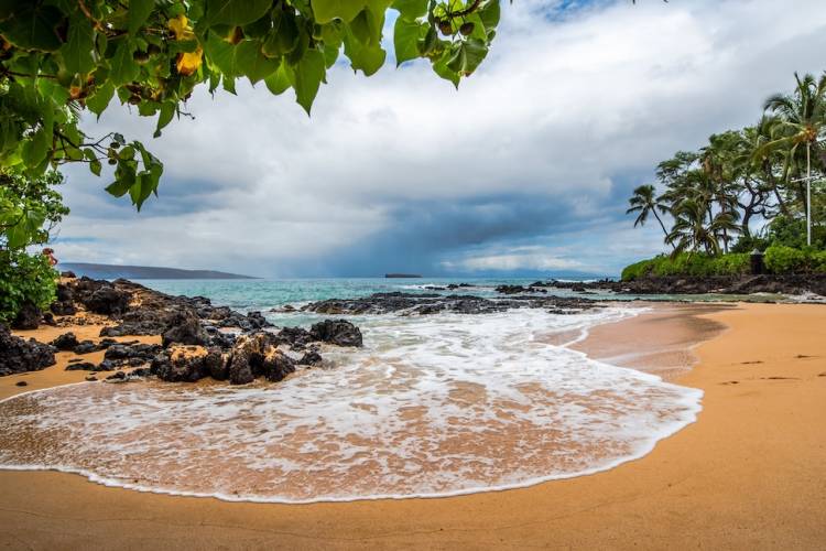 rain over the ocean off beach in Maui