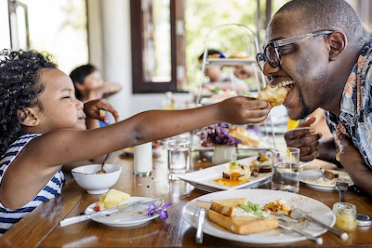 father and daughter eating breakfast at a restaurant