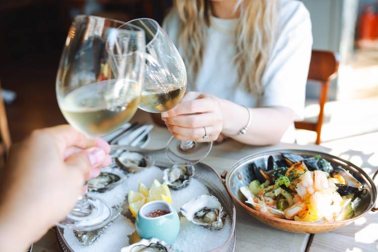 couple out to a nice seafood dinner toasting with wine glasses