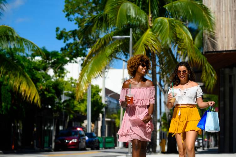 two women walking at a tropical outdoor shopping plaza