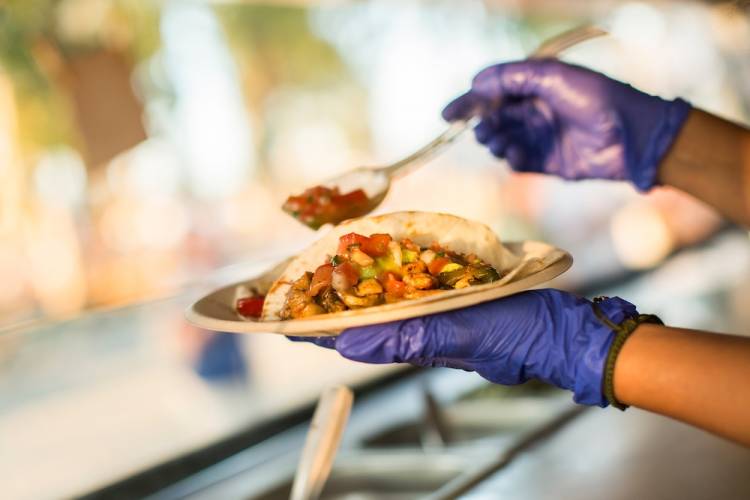 person serving tacos from a food truck