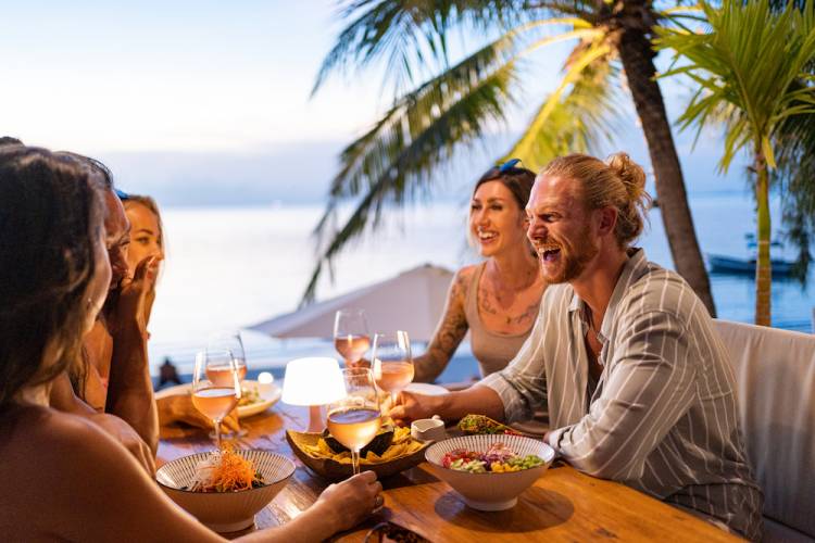 friends dining outside in tropical setting