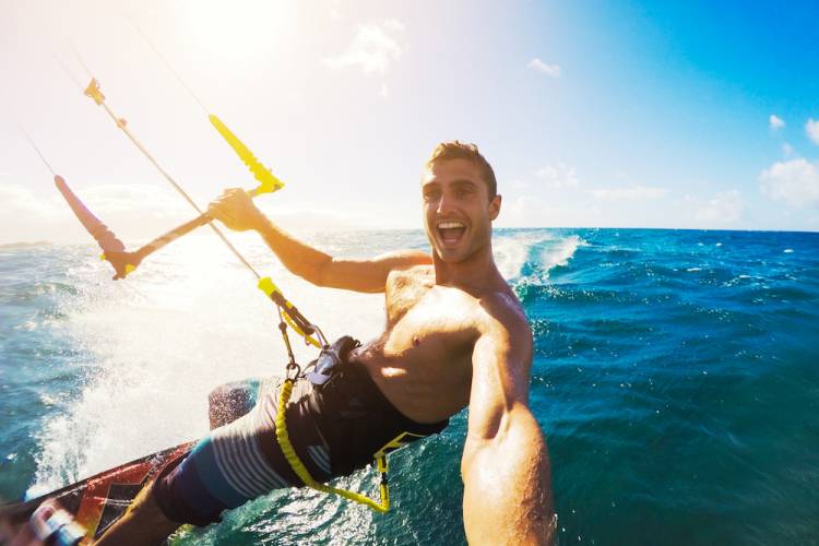 man filming himself as he kiteboards